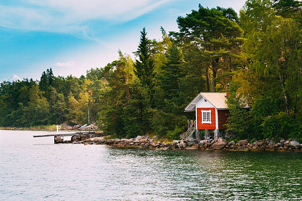 rouge en bois de petite cabane en bois de sauna finlandais île automne - red cottage small house photos et images de collection