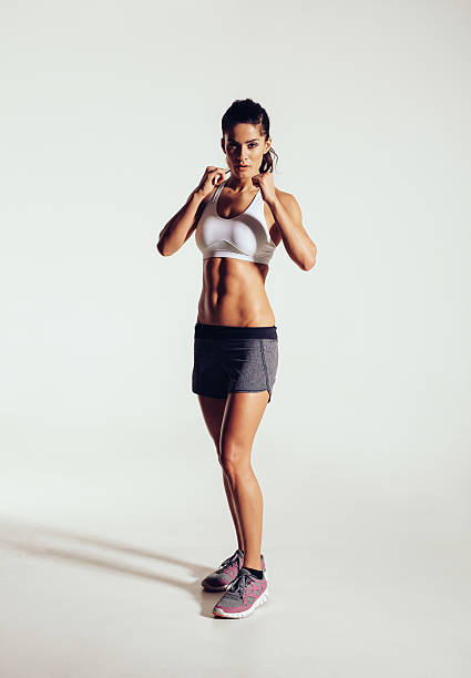 solide jeune femme faisant de l'exercice en salle de boxe - ready to fight photos et images de collection