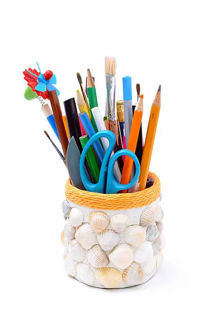 pencils, brushes, plastic knife, scissors in handmade pencil-box isolated