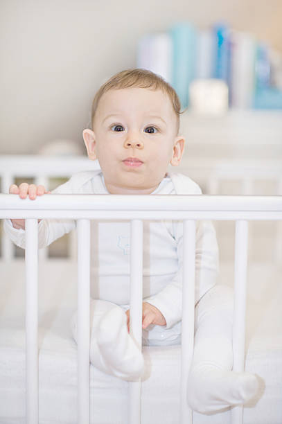 istock Happy baby boy posing in cot at home, cute child 534890415