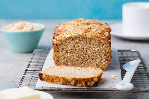 Healthy vegan oat and coconut loaf bread, cake on a cooling rack Grey stone background