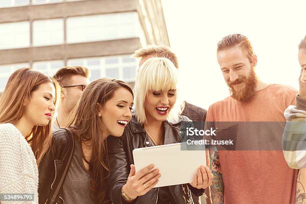 Group Of Friends Using Digital Tablet Outdoor Stock Photo - Download Image Now - Blond Hair, Digital Tablet, Group Of People