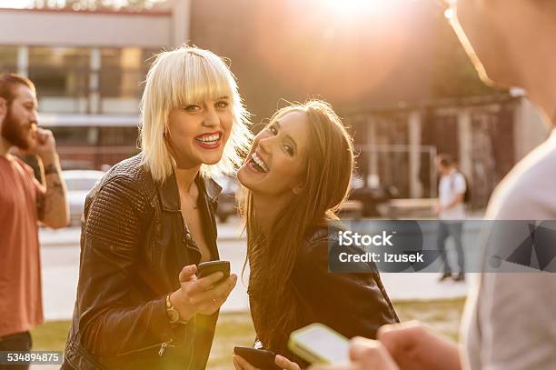 Two Young Woman Using Smart Phones Outdoor Stock Photo - Download Image Now - Friendship, Outdoors, Togetherness