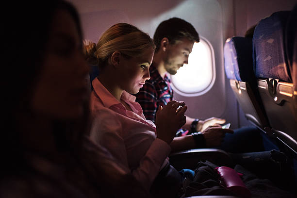 mujer con smartphone en avión. - airplane passenger indoors inside of fotografías e imágenes de stock