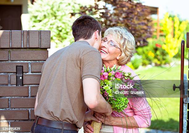 Grandson Giving Flowers To His Grandmother Stock Photo - Download Image Now - Mother, Mother's Day, Bouquet