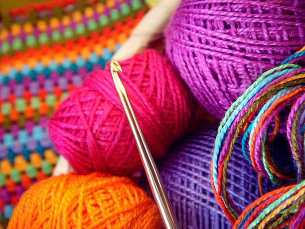 Crochet hook and balls of colored thread Crochet hook with a ball of colored yarn and knitwear crochet photos stock pictures, royalty-free photos & images
