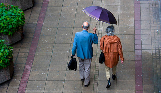 dia chuvoso na cidade - umbrella senior adult couple autumn imagens e fotografias de stock