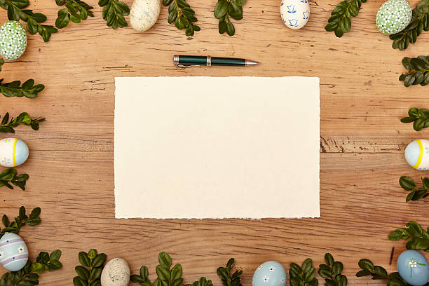 Easter eggs and twigs, blank card and ballpen on wood