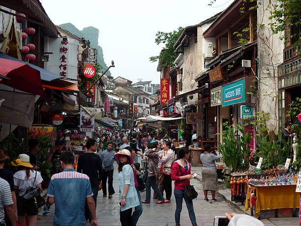 Yangshuo, China - April 28, 2014: Crowd of chinese tourists on the streets of Yangshuo, a popular village famous for its beautiful location, surrounded by karst limestone hills in South China., Guangxi Region