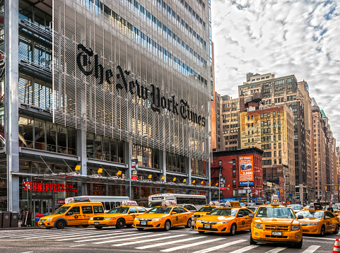 New York city, USA - December 01, 2013: The New York Times building and characteristic NYC Yellow Taxi Cab, waiting the street light turns to green.