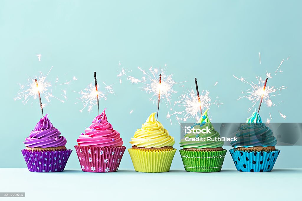 Colorido cupcakes con sparklers - Foto de stock de Magdalena con glaseado libre de derechos