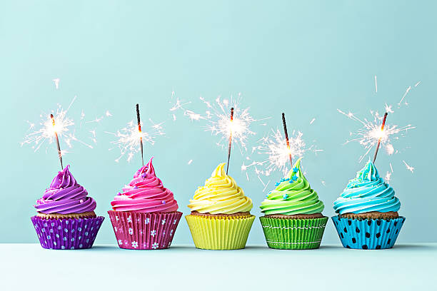 Colorful cupcakes with sparklers Row of colorful cupcakes with sparklers cupcake photos stock pictures, royalty-free photos & images