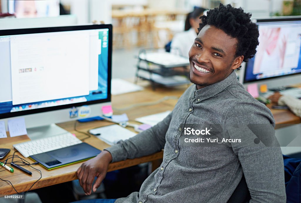 Yep, my work is great! Portrait of an handsome young man sitting at her workstation in an office 20-29 Years Stock Photo