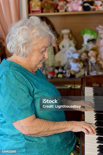 One Old Lady Playing The Piano Stock Photo - Download Image Now - People, Playing, Upright Piano