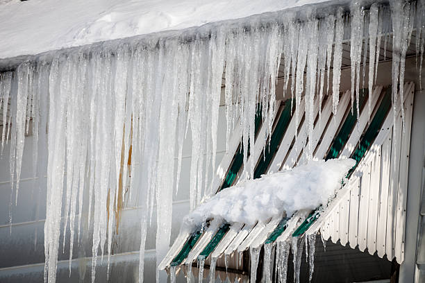 istock Many Thick Icicles Hanging From Ice Clogged House Roof Gutter 534924687