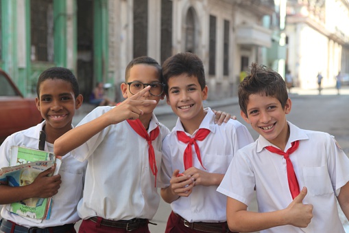 Havana, Cuba-February 8, 2013-School boys  mug for the camera while holding their school books.