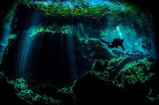 Beauty of underwater caves Scuba diver exploring the underwater cenotes in Mexico near Puerto Aventuras. Caves are dark and the light always gives different amazing ambient underwater. puerto aventuras stock pictures, royalty-free photos & images