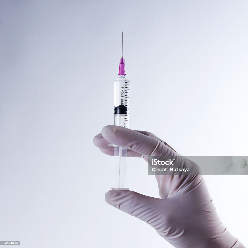 Hand in glove with syringe. Hand in glove with syringe, health care and medical concept. 2015 Stock Photo