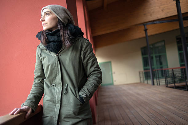 Woman looking out from balcony in winter