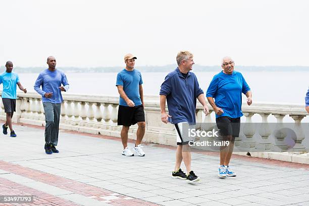 Group of men wearing blue shirts, power walking