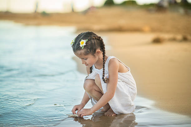istock Young girl playing with starfish on tropical beach 534973319
