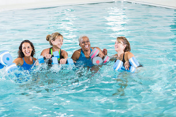 grupo de mulheres na água aeróbica aula de exercício físico - fun senior adult aerobics exercise class imagens e fotografias de stock