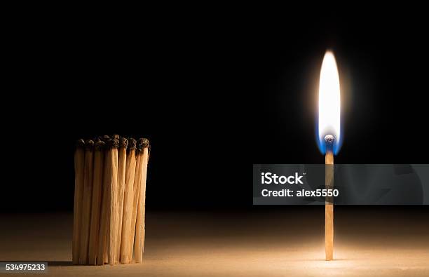 Crowd Of Burnt Matches Standing Before Match On Fire Concept Stock Photo - Download Image Now