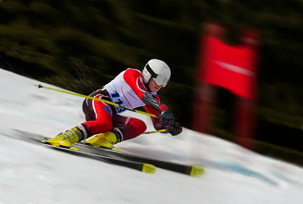 Side view of young male skier during the giant slalom race, motion blurred