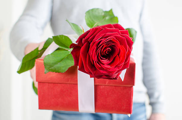 istock Man holding a gift and a red rose 534977435