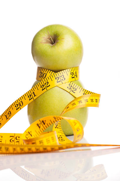 istock Concept for a diet. Apple wrapped in measuring tape 535003343