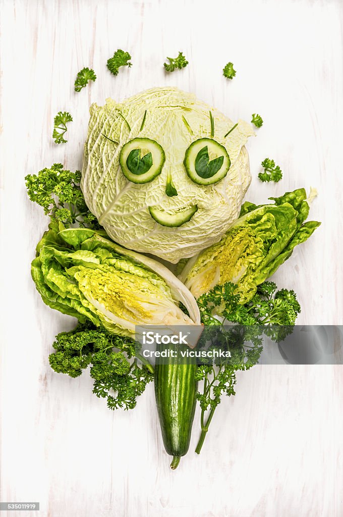 funny girl face made of  green vegetables, cucumber and lettuce funny girl face made of  green vegetables, cucumber and lettuce on white wooden background Human Face Stock Photo