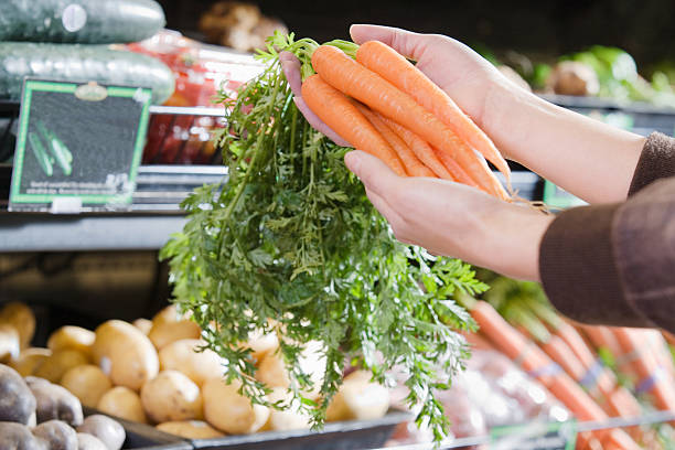 Young woman holding a bunch of carrots