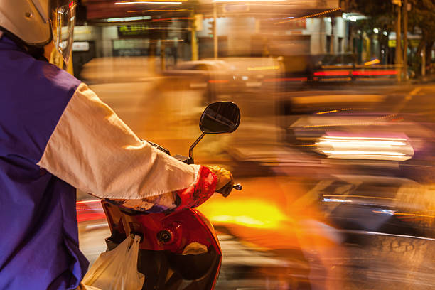 istock scooterist standing at a junction at night 535023575