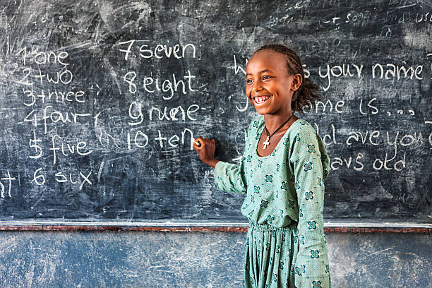 niña africana es el aprendizaje de inglés - africa child village smiling fotografías e imágenes de stock