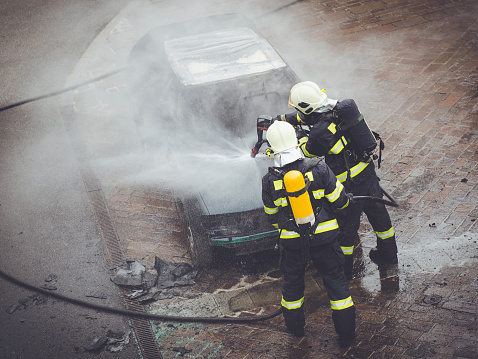 Firefighters fighting car fire