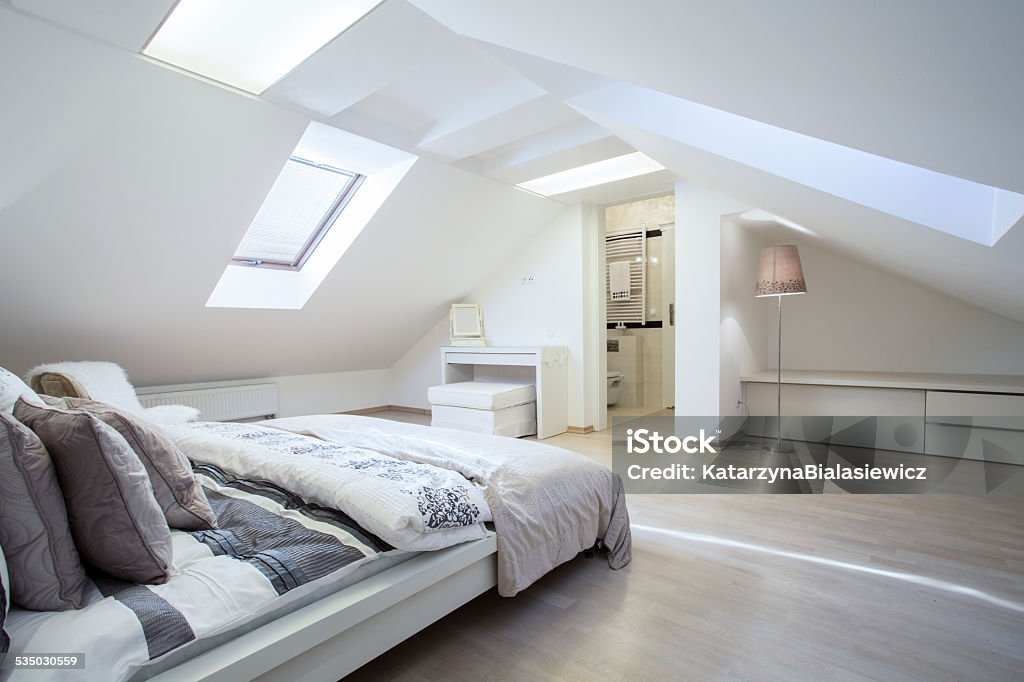 Spacious and fashionable bedroom Spacious and fashionable bedroom connected with bathroom Attic Stock Photo