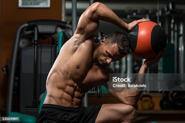 Muscular Man Ejercicio Con Bola Médica Foto de stock y más banco de imágenes de 2015 - 2015, Actividades y técnicas de relajación, Adulto