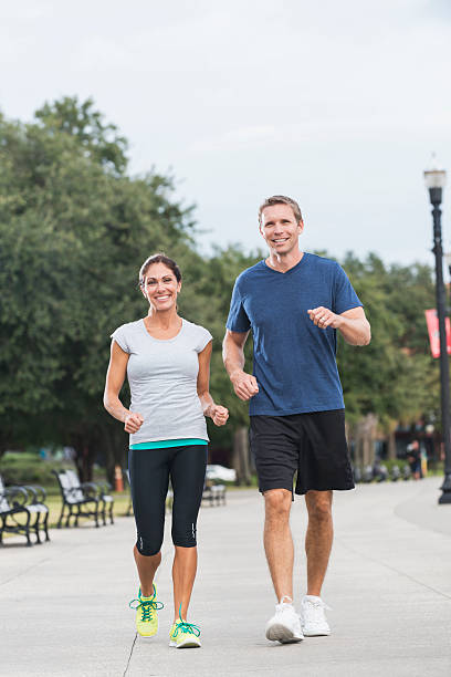 istock Mature couple jogging together in a park 535040709