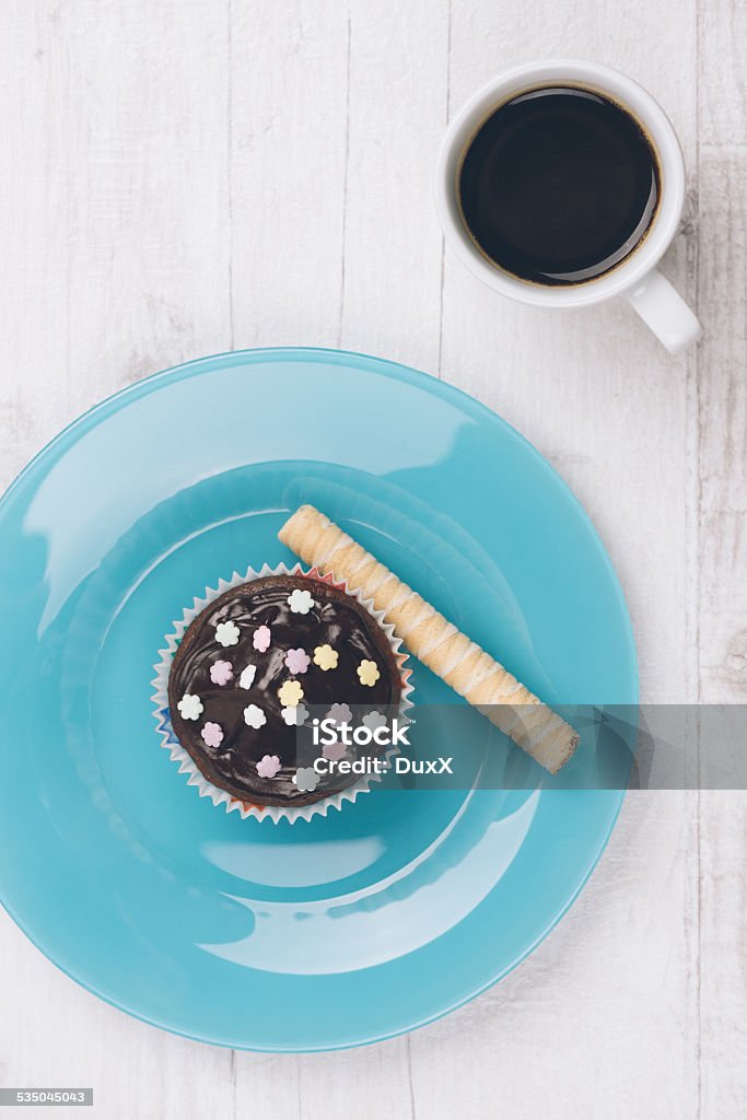 Chocolate Muffins Fresh homemade muffin decorated with sugar flowers photographed from above on white wooden table. 2015 Stock Photo