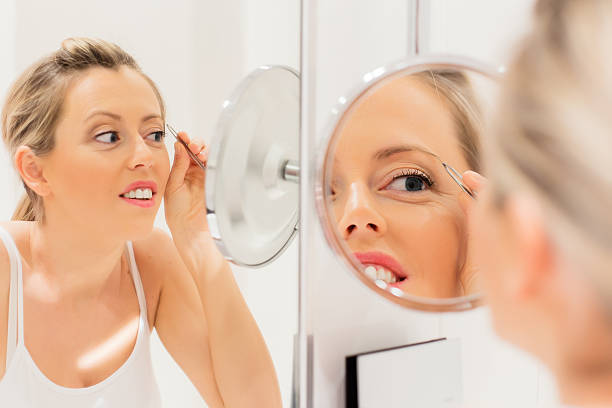 istock Young woman tweezing eyebrows 535045171