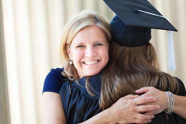 szczęśliwa matka z córka w gratulować objąć university ceremonia ukończenia szkoły - high school student graduation education friendship zdjęcia i obrazy z banku zdjęć