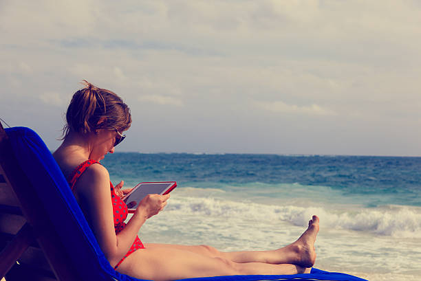 istock woman with touch pad on summer beach 535076437