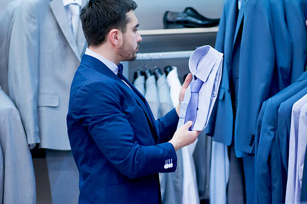 istock Young  man chooses tee - shirt at a shop. 535077593