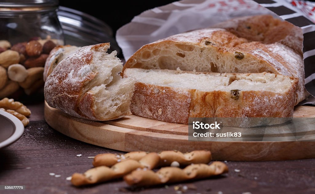 different bread different bread on a round cutting board on a wooden table 2015 Stock Photo