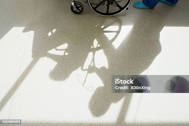 Nurse Pushing Patient In Wheelchair Stock Photo - Download Image Now - Corridor, Entrance Hall, Focus on Shadow
