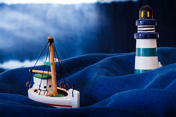 Wooden boat mini Storm near lighthouse stock photo