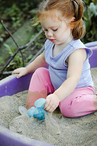 istock Little Girl Playing in Sandbox Outside 535107637