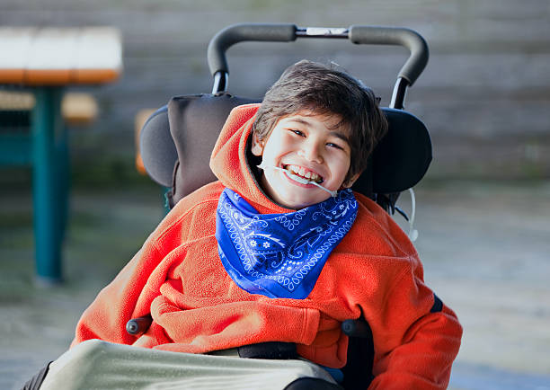 잘생김, 행복함 biracial 8 주행연수 늙음 남자아이 웃는 in 휠체어 스톡 사진