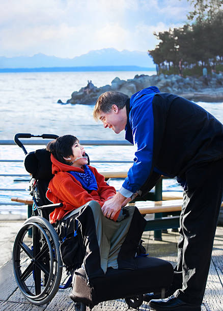 istock Handsome father talking with disabled biracial son outdoors by lake 535108717