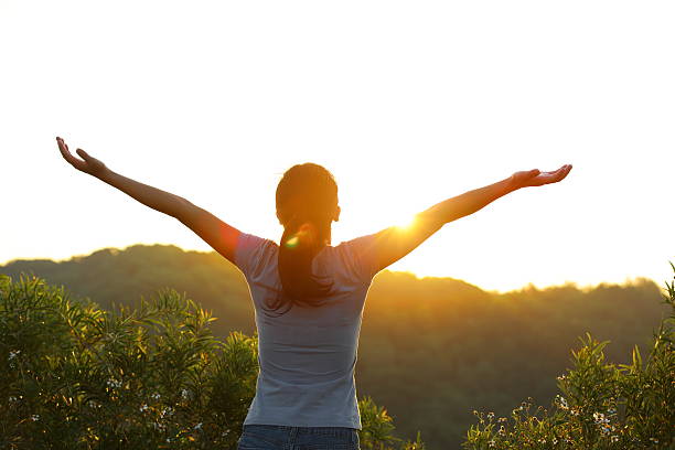 istock strong confident woman open arms to sunrise 535110219